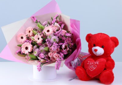 Soft Pink Celebration Teddy Combo featuring gerberas, lilies, baby roses, statice pink, chrysanthemums, and a teddy arranged in pink wrapping for gifting