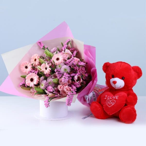 soft-pink-celebration-teddy-combo Soft Pink Celebration Teddy Combo featuring gerberas, lilies, baby roses, statice pink, chrysanthemums, and a teddy arranged in pink wrapping for gifting