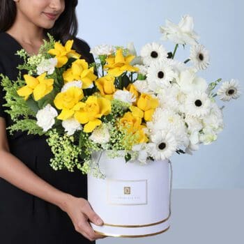 Sunlit Elegance Mixed Flower Box featuring yellow roses, white roses, carnations, gerberas, orchids, and fillers arranged beautifully for gifting and décor