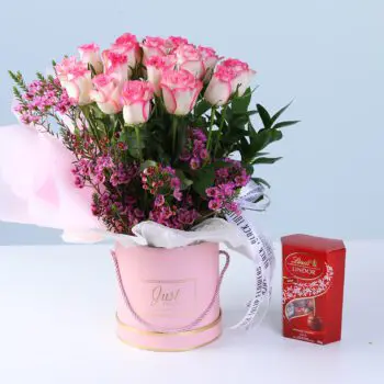Sweet Bloom Surprise Box with Lindt featuring double pink roses, wax flowers, greenery, and Lindt chocolates arranged in a pink luxury box for gifting