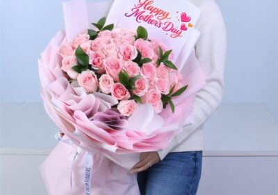 A soft and timeless bouquet of pink Titanic roses paired with fresh ruscus foliage, finished with a message card and wrapped in a light pink sheet with a white satin ribbon for an elegant touch.