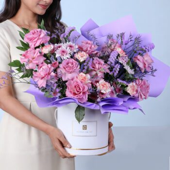 Violet Garden Floral Box featuring purple roses, bi-color carnations, chrysanthemums, and filler flowers arranged in an elegant luxury bouquet
