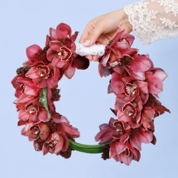 Modern Cymbidium Bridal Bouquet featuring red cymbidium orchids, skimmia berries, and sculptural steel grass in a contemporary bridal arrangement