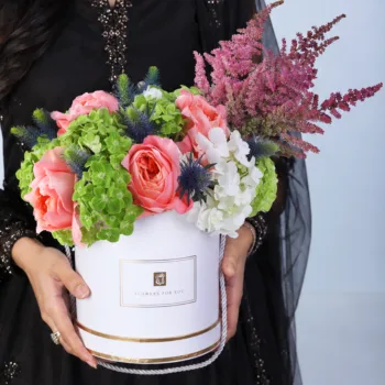 Royal Eid Floral Gift featuring peach roses, red astilbe, blue eryngium, and green and white hydrangeas arranged in a white signature Eid box